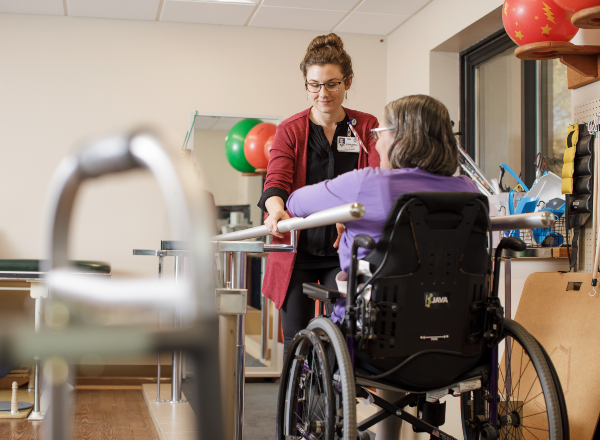Therapist helping a patient in wheelchair Therapist helping a patient in wheelchair